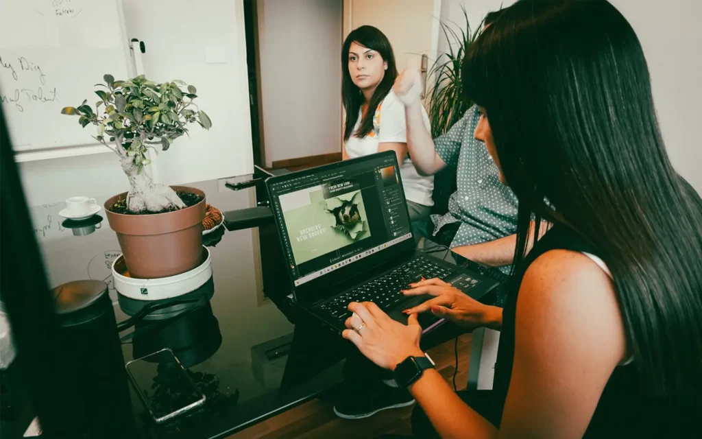 Senior graphic designer working on project next to partners and clients in a digital marketing agency