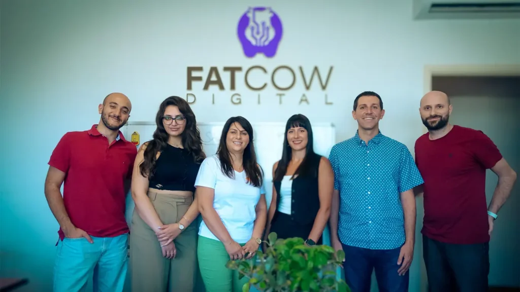 The Fatcow Digital digital marketing team standing in front of the logo with some of the agency's partners
